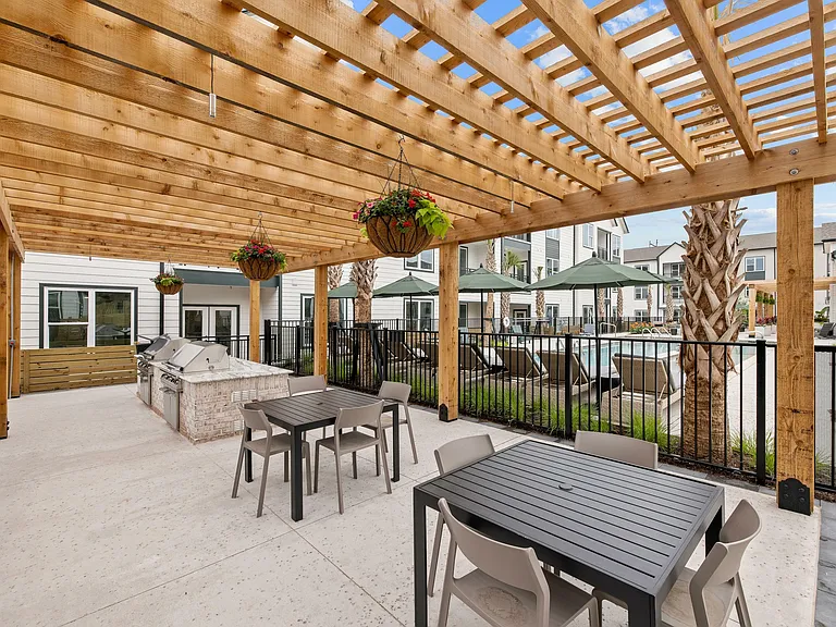 Resort-style apartment pergola with outdoor grilling stations, dining areas, and poolside gathering spaces.