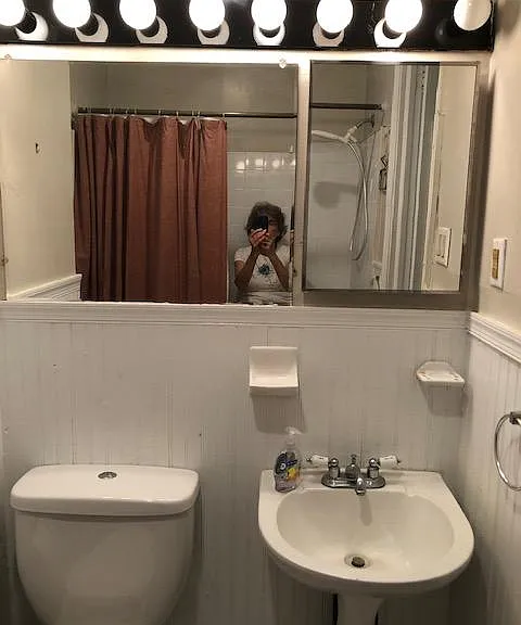 Mirrored wall with vanity lights over fixtures