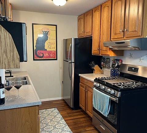 Stainless steel refrigerator and range in kitchen.