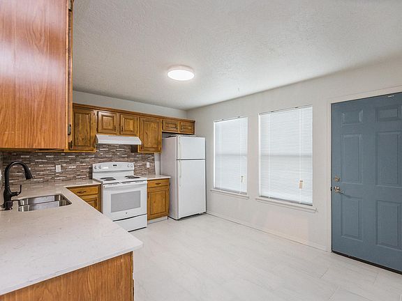 Kitchen has granite kitchen counter tops, dishwasher, stove cook top, refrigerator, new sink & faucet, new light fixtures, painted metal door