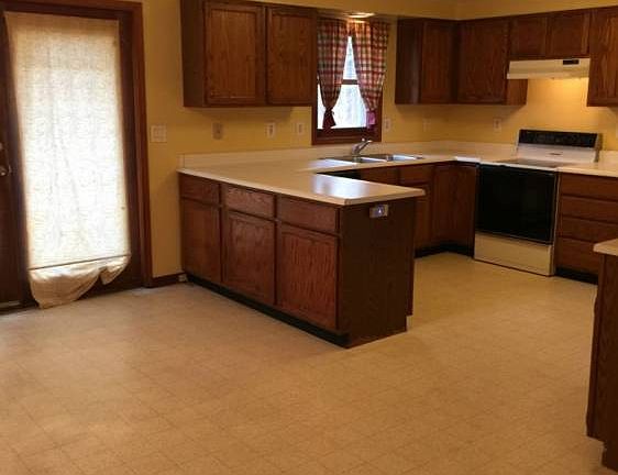 The kitchen is open with an eating area and patio door leading to the deck.