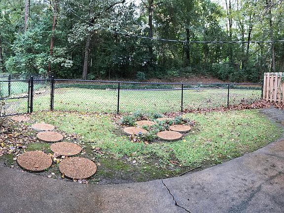 Fenced backyard with additional space behind fence