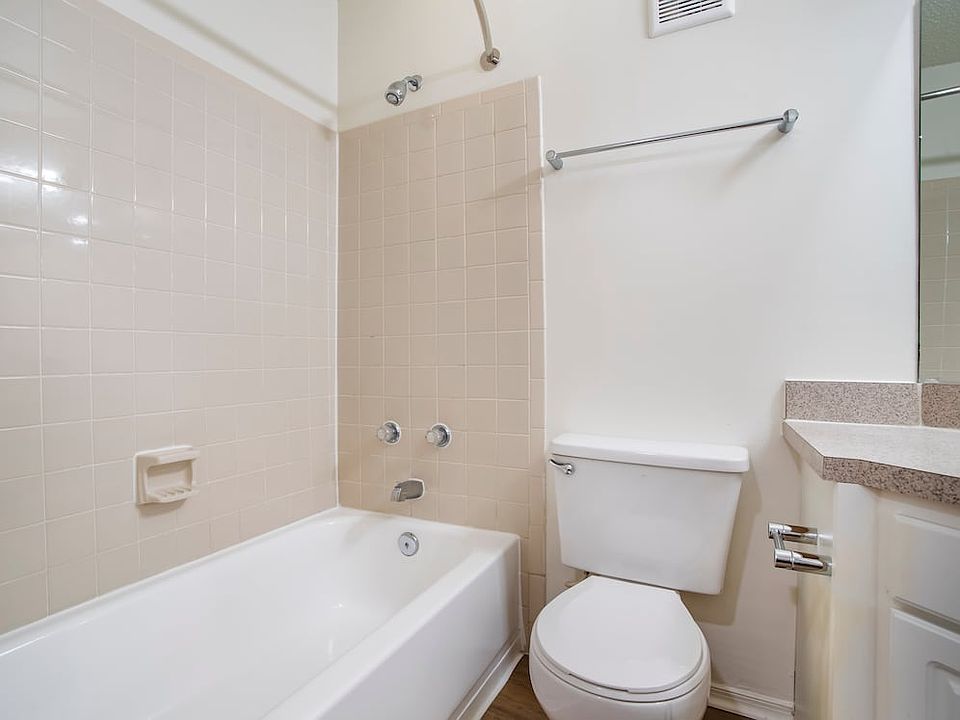 Renovated Package II bath with laminate countertops, white cabinetry, and hard surface flooring