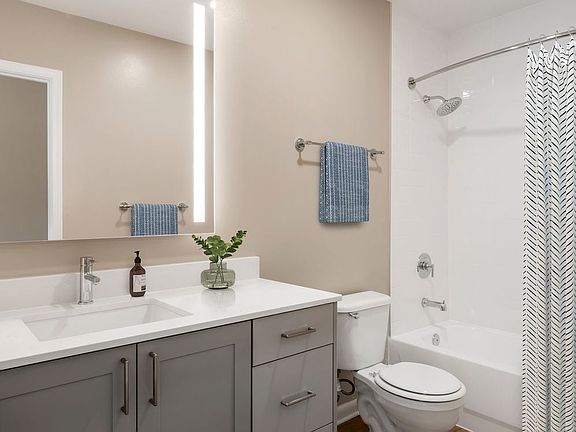 Signature Collection bath with grey cabinetry, white marbled quartz countertops, and hard surface flooring