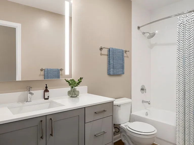 Signature Collection bath with grey cabinetry, white marbled quartz countertops, and hard surface flooring