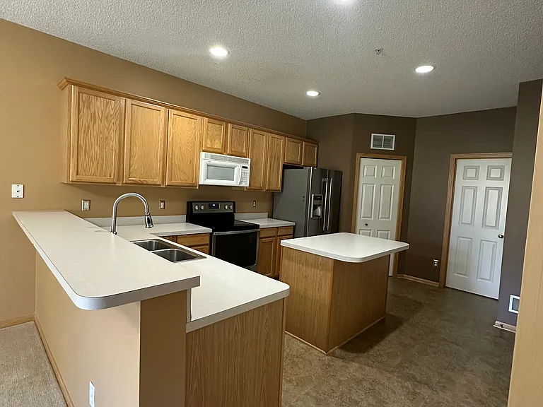 Breakfast bar with view of kitchen. Pantry is to the right. Half bath is off from the kitchen.