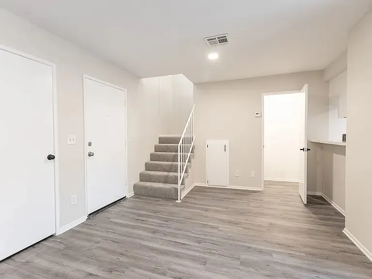 living area, view of powder room and kitchen pass thru counter, closet ,front door. units vary