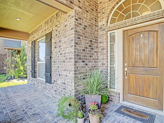 This all brick and stone home has an inviting front porch and solid wood door.