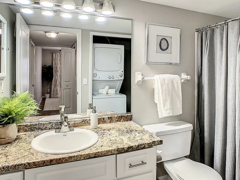 Pamper yourself in a spa-like oasis with white cabinets, granite-inspired countertops, and a relaxing garden.