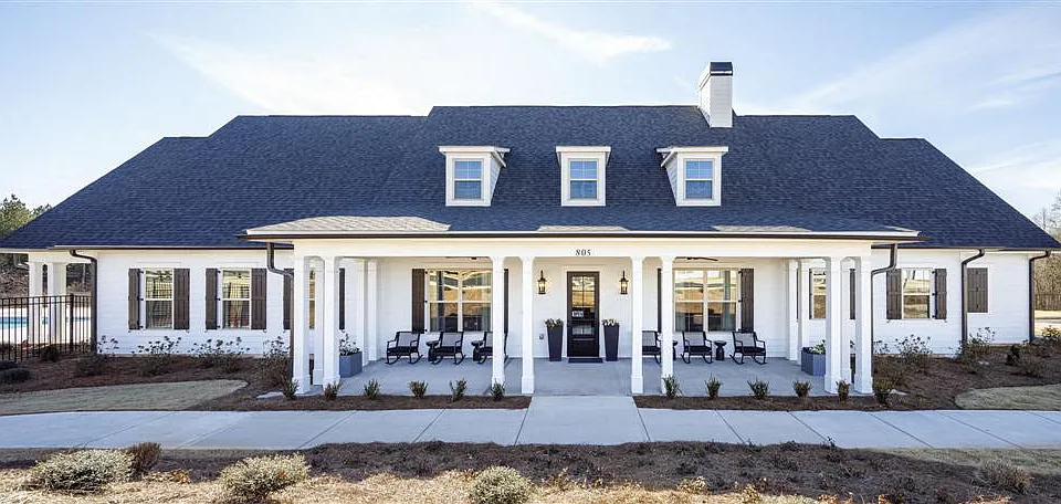 Clubhouse exterior with ample parking for future residents and visitors.