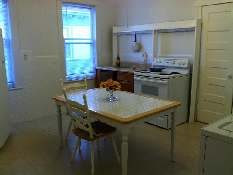 Kitchen includes table, stove and refrigerator