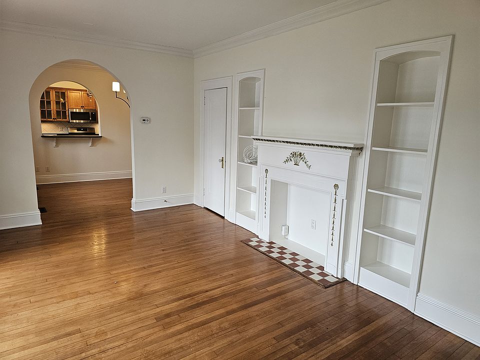 Living room with faux fireplace, looking through dinning room to the kitchen