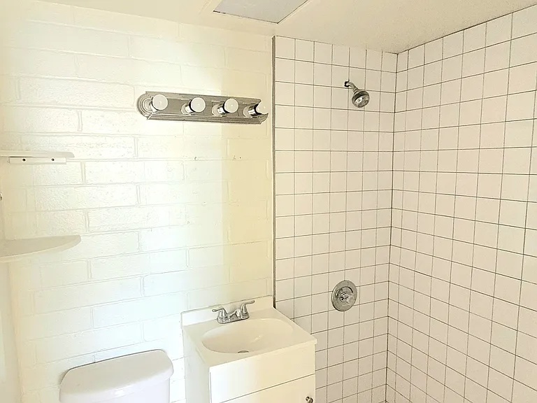 Bathroom with fresh paint, new fittings and new shower with brand new white tile.