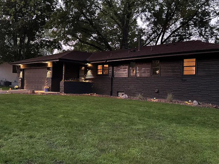Modern black exterior with warm lighting throughout perimeter.