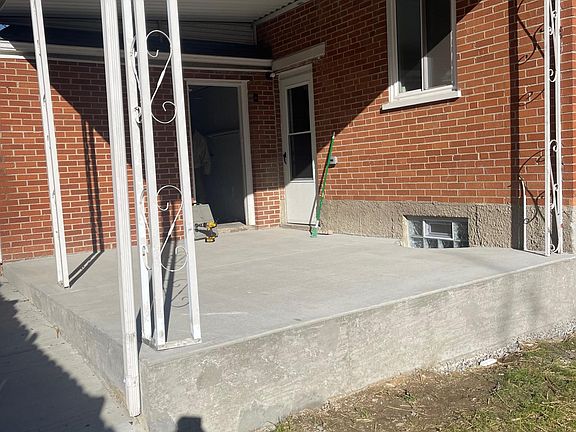 Covered side patio in large backyard.