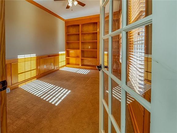 A private den with French doors, judges paneling and custom built-in shelving is tucked at the front of the home.
