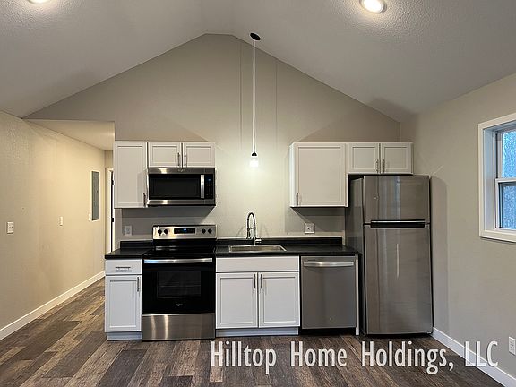 Kitchen is equipped with a range, microwave, dishwasher, and refrigerator.