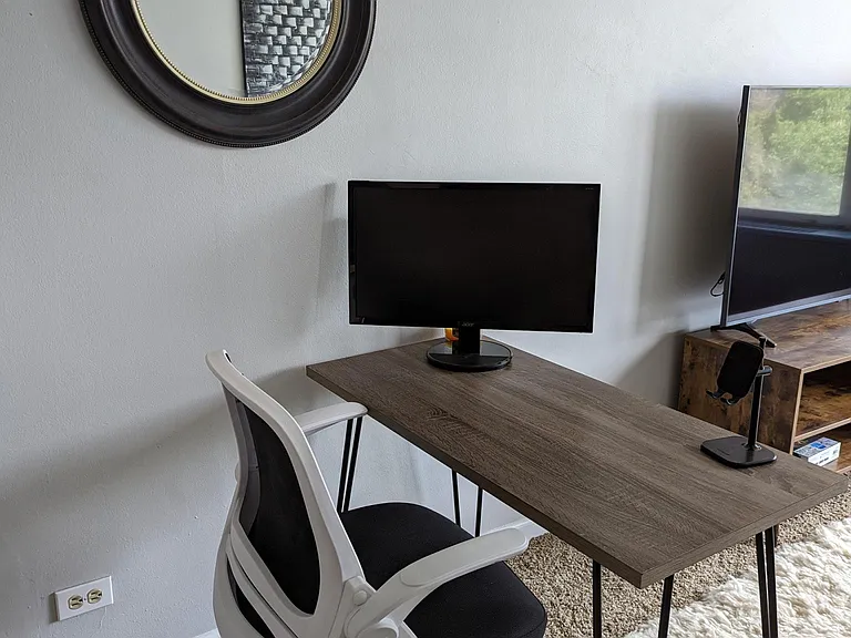 Desk set up including monitor and cell phone stand.