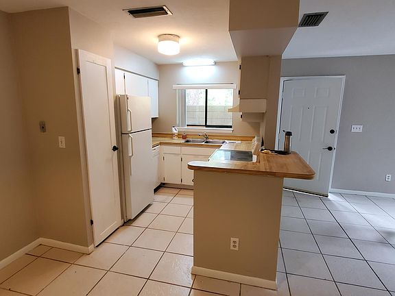 Front door and living room on the right. Kitchen on the left. Includes smooth top stove and dishwasher. Nice sized pantry is next to the fridge. The kitchen window looks out on the front porch.