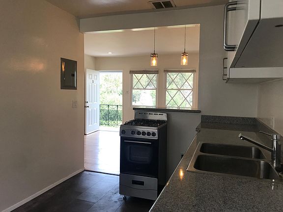 Kitchen with range oven. Breakfast counter behind with LED pendant lights *Picture is not of the actual unit but is similar.