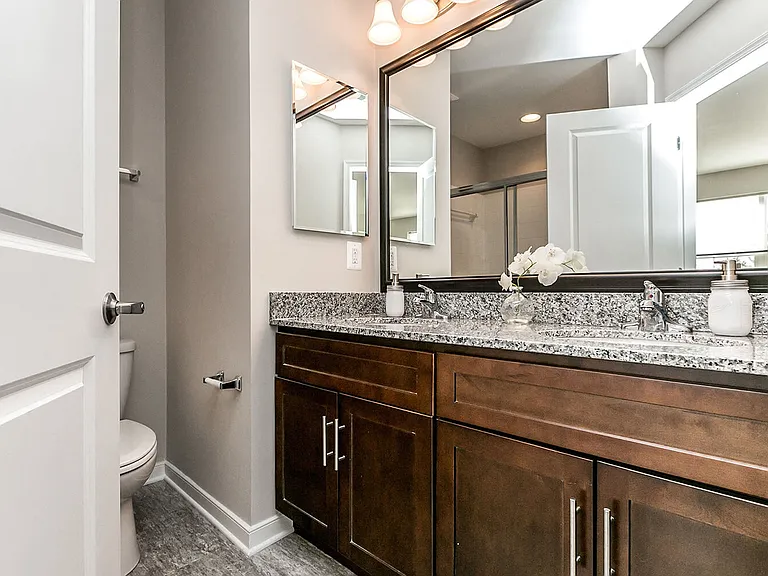 Master bath featuring granite, solid-wood cabinetry and double vanity