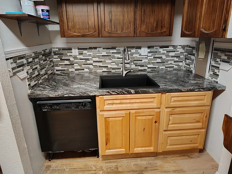 The lower counters are stained the darker color to match with the upper cabinets