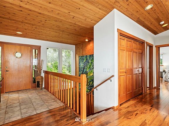 Entrance to home with tiled entry. Storage/pantry to the left and master bedroom down the hall.