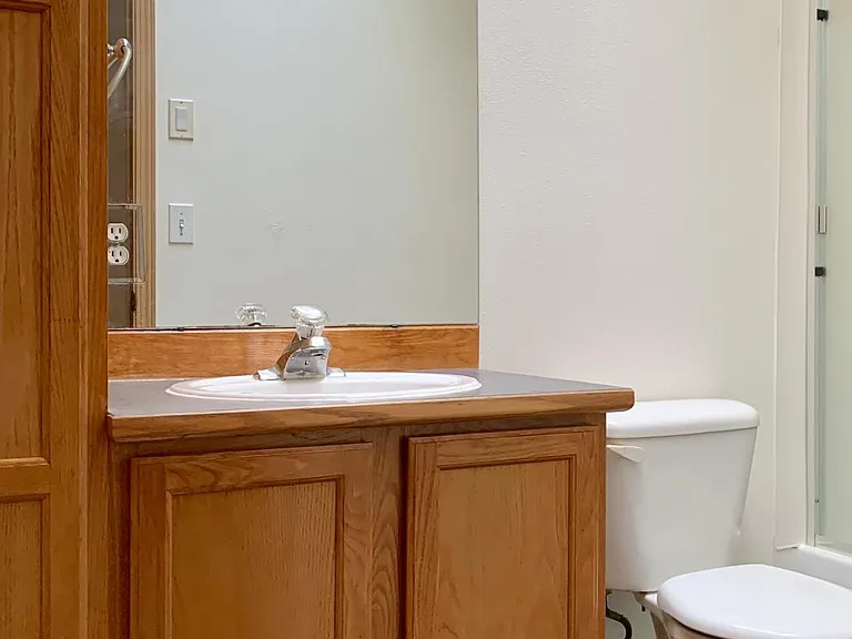 Hallway full bathroom with granite floor, skylight and cabinets for extra storage