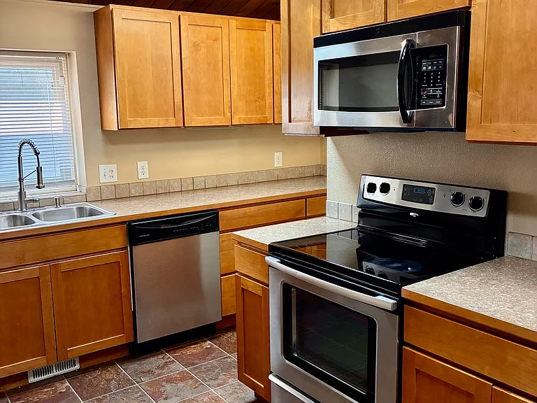 Kitchen area with double sink with a window and skylight.