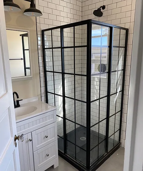metal and glass shower enclosure and remodeled bath