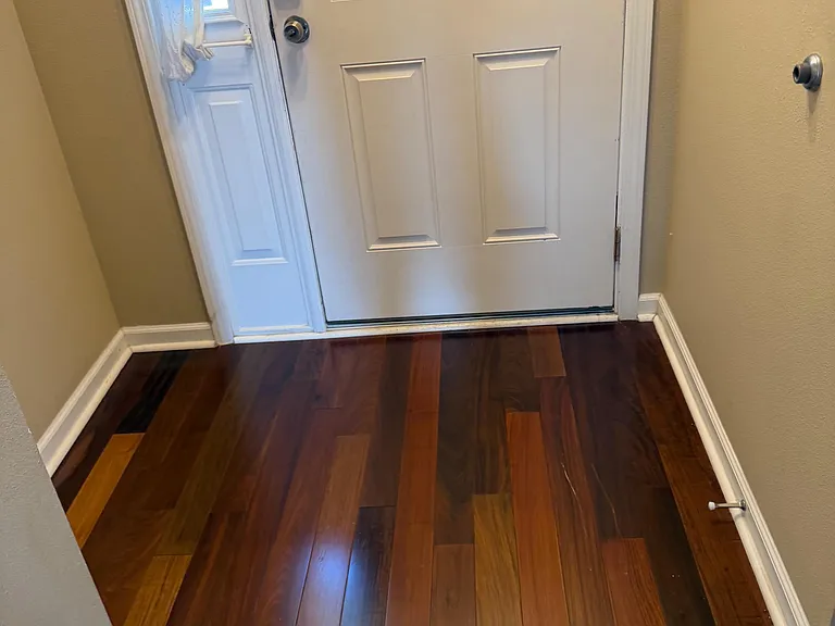 Entry foyer with durable wood-look flooring, side window for natural light, and secure front door with keypad access.