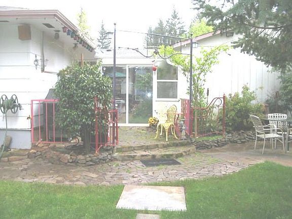Back of house. Garage on right. Enclosed patio center. Bedroom on left.