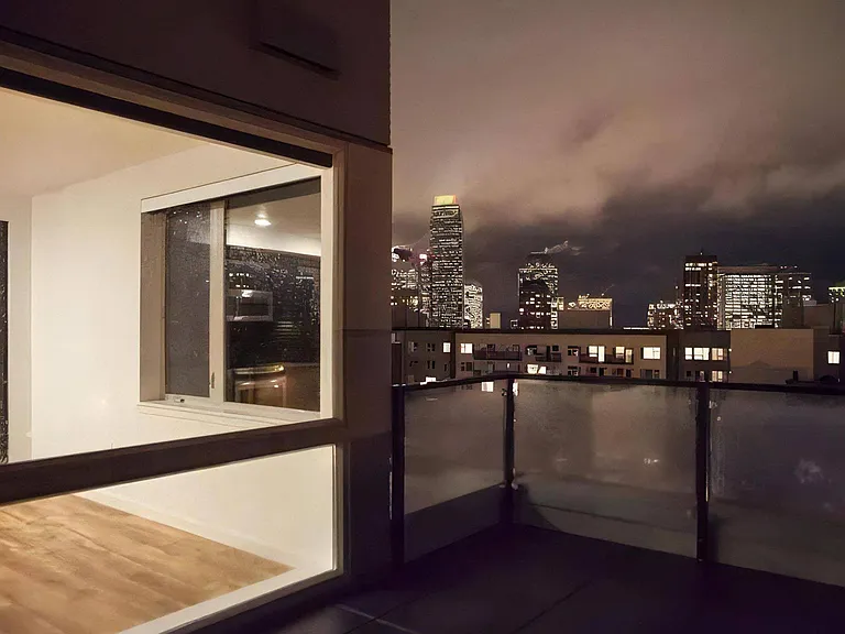Nighttime Apartment View with Lit Buildings and Skyline in Background