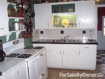 Kitchen : Black and white tile countertops. Ceramic tile floors Laundry room off kitchen
