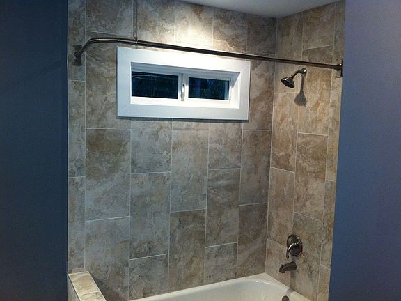 Master bath with beautiful tile and specially made corner shower rod