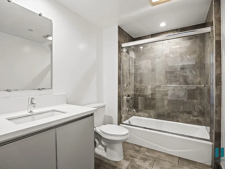 Bathroom with Shower Bath with Glass Door, and Vanity Cabinet Storage