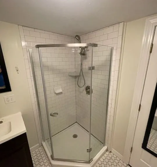 The bathroom has a subway tiled shower, vintage tiled floor and views of the cemetery.