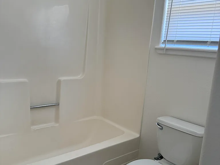 middle and rear of bathroom with brand new toilet seat.