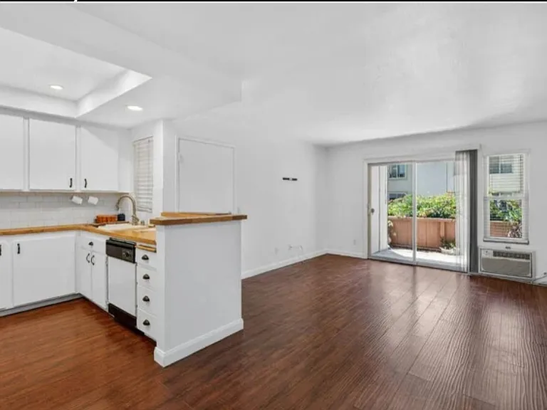 Kitchen, front door, den and enclosed back patio, as seen from dining area.