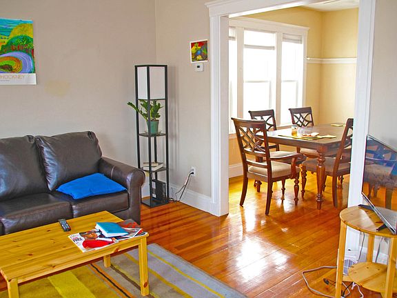 Open plan living room (left) and dining room with 6 seat table.