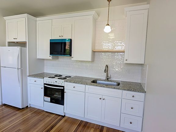 Kitchen with new appliances, tile backsplash and granite counters