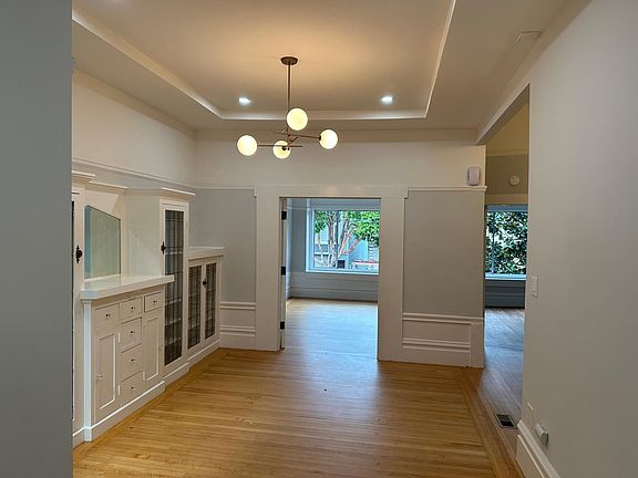 Looking through the dining room into the living room, secondary bedroom is on the right