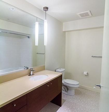Roomy bathroom with large mirror, tile floor, and counter sp