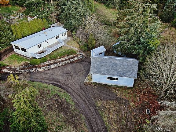 Driveway comes up (at bottom of photo) and continues around the house to a carport. House is positioned to maximize sun and view. If you look closely you will see that there is a space in the deck ready for a hot tub.