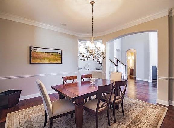Fabulous formal dining room with hardwood flooring, gorgeous archway and crown moldings