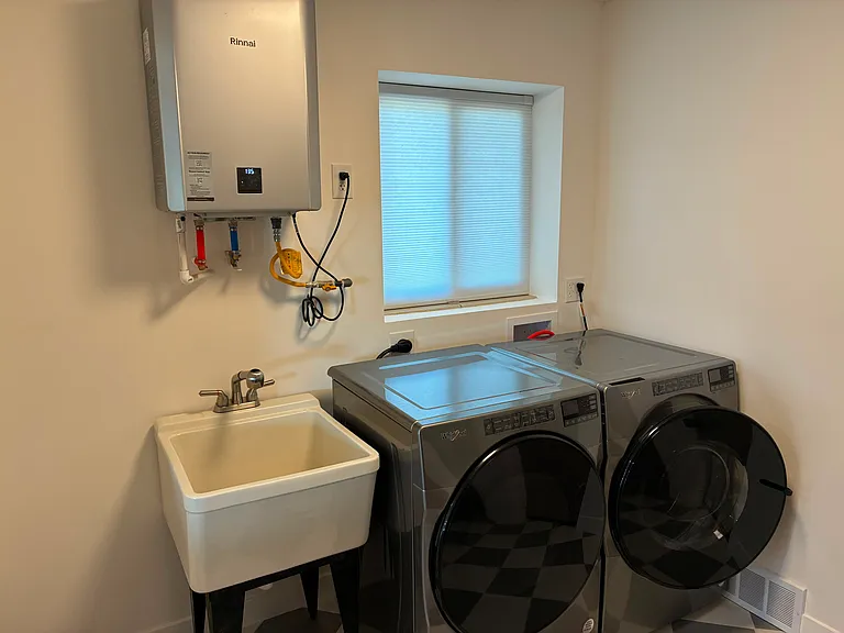 Laundry with new washer, dryer, on-demand hot water heater.