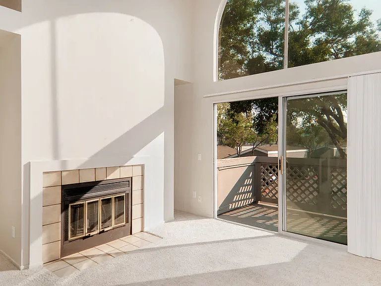 Carpeted Living Room with Fireplace and Balcony