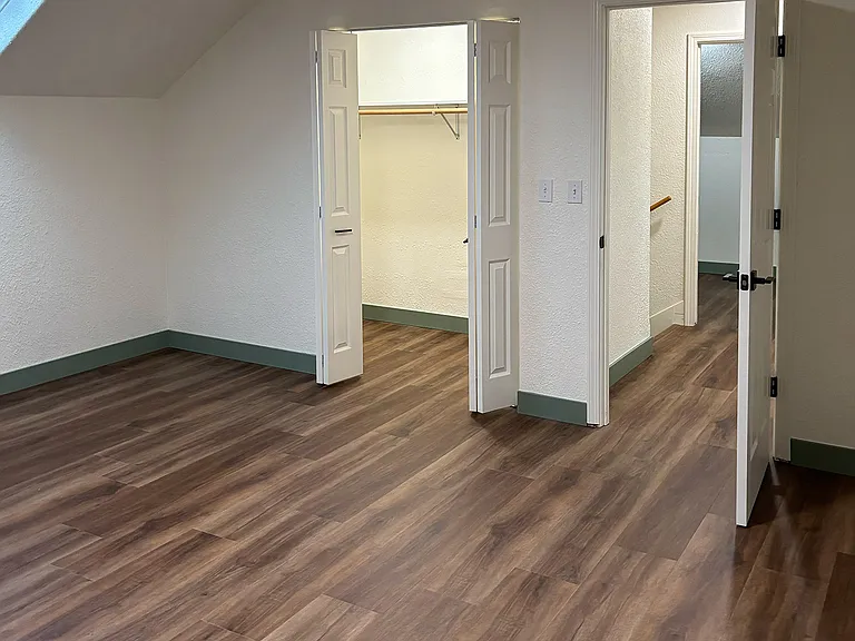 Inside bedroom, with view of closet and bonus room entry in the background.