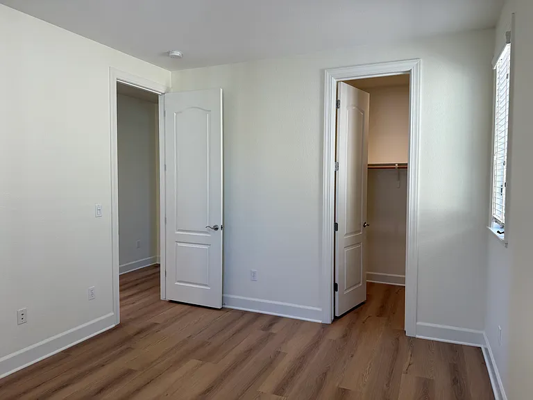 Spacious Bedroom #2 features multiple windows, vinyl flooring, walk-in closet, a separate bathroom sink and share a Jack-and-Jill style bathroom for the bathtub and toilet.