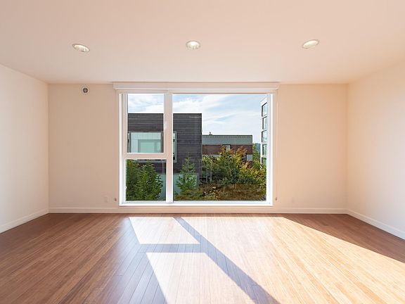 Open layout living room with floor-to-ceiling west-facing window
